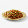Plated dish of noodles with vegetables on a white background